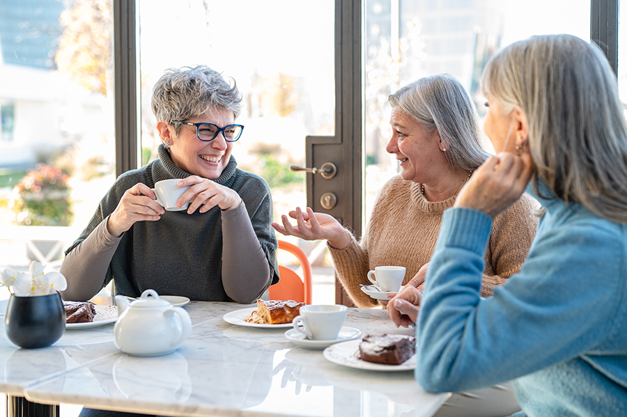 A group of older women chatting over coffee.